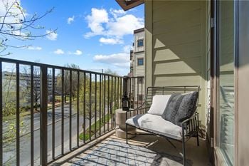 A balcony with a chair and a table.
